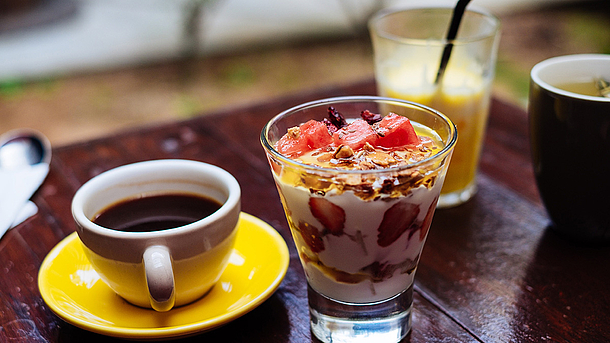 Ein Müsli, Kaffee und Saft auf einem Tisch.